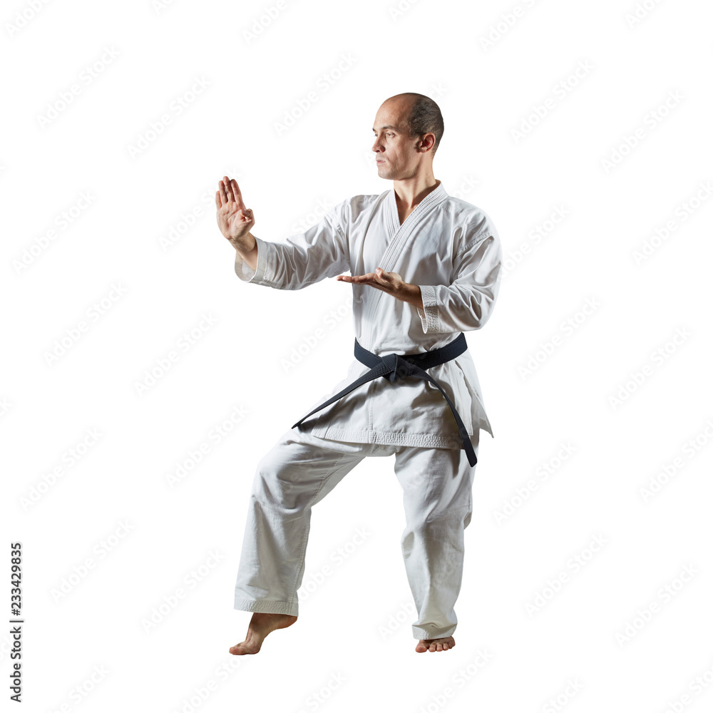 Athlete performs formal karate exercises on a white isolated background Athlete performs formal karate exercises on a white isolated background