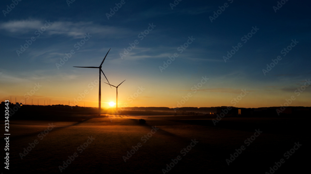 Obraz premium Windmill at Sunset . Wind turbines farm . 