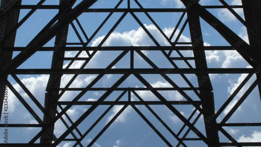 Detail of electrical pylon with time lapse clouds moving behind steel girders. Detail of electrical pylon with time lapse clouds moving behind steel girders.
