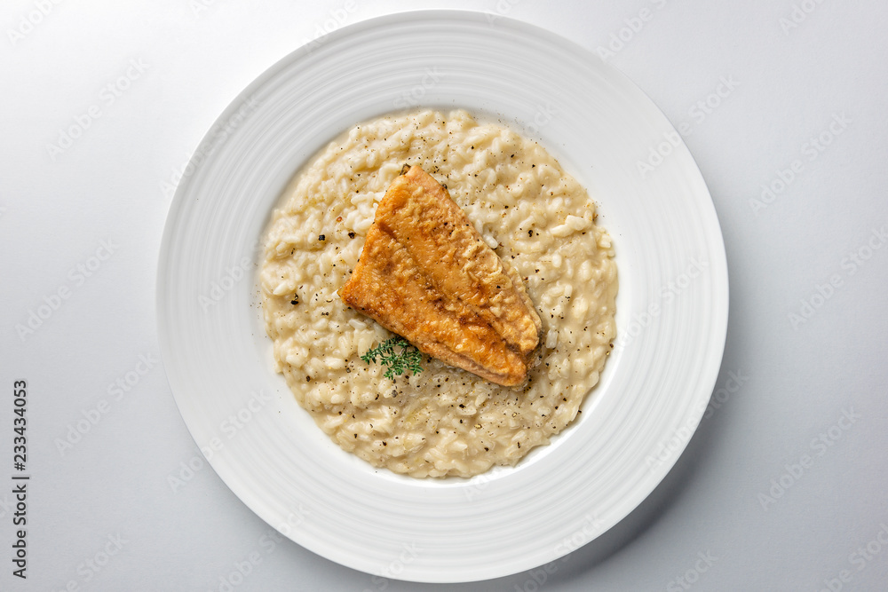 Dish of Parmesan risotto with fish fillet Dish of Parmesan risotto with fish fillet