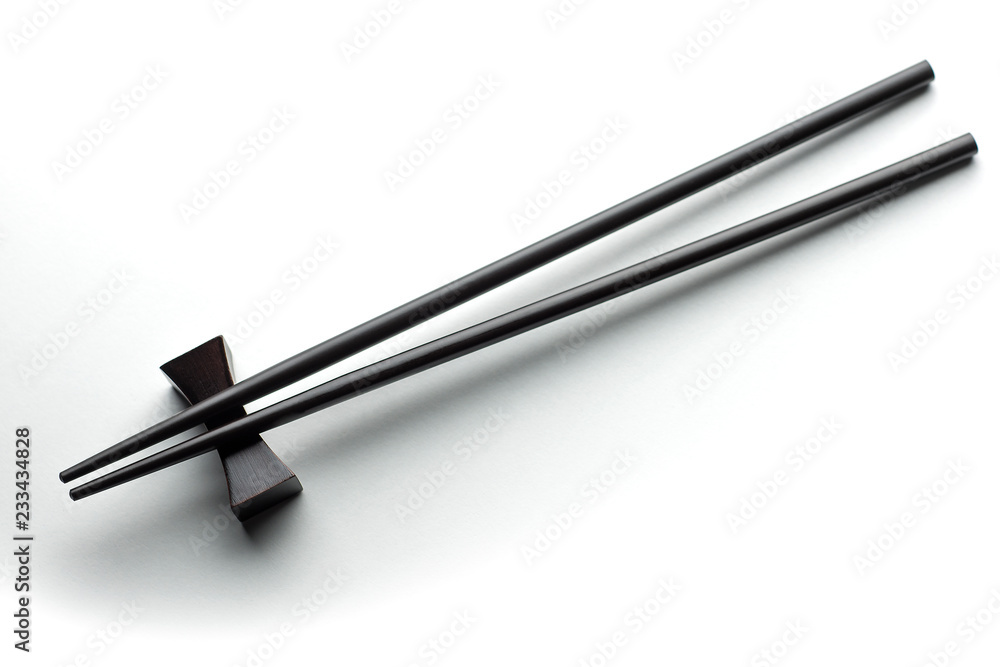 Black chopsticks on a white background