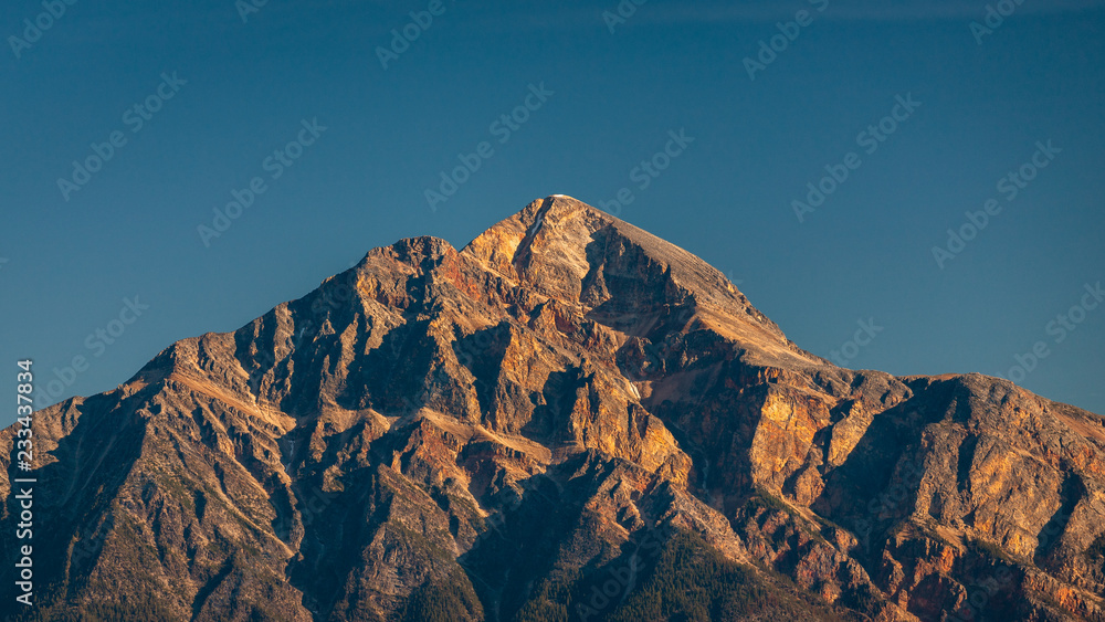 Golden Rocky Mountain Peak Under Blue Sky Close Up