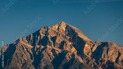 Golden Rocky Mountain Peak Under Blue Sky Close Up