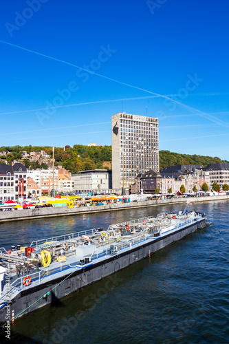 Fotografie View to Meuse River with an oil tanker, Liege urban skyline, Belgium