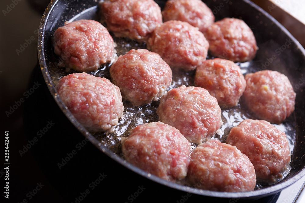 Fried meat patties are cooked in a pan in the oil in the kitchen with steam