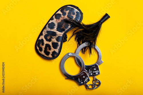 Photography Sex concept. Different erotic toys on yellow background.