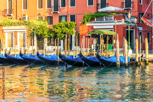 Traditional gondolas by the pier in the channel of Venice
