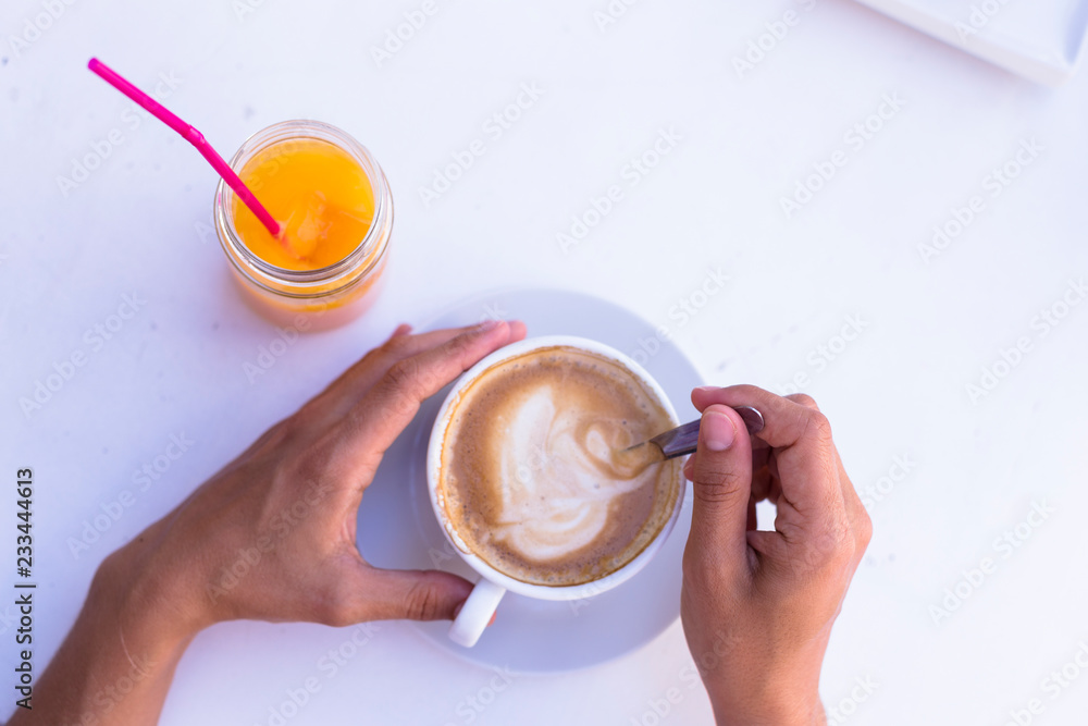 female hands holding a cup of coffee, oranges juice besides. Healthy breakfast. top view female hands holding a cup of coffee, oranges juice besides. Healthy breakfast. top view