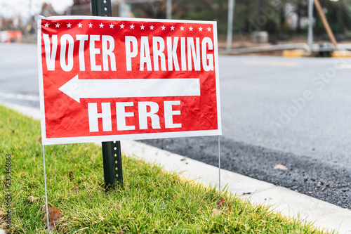 Voter parking here sign at school national federal polling election station with arrow on sidewalk, street road, nobody, red color photo