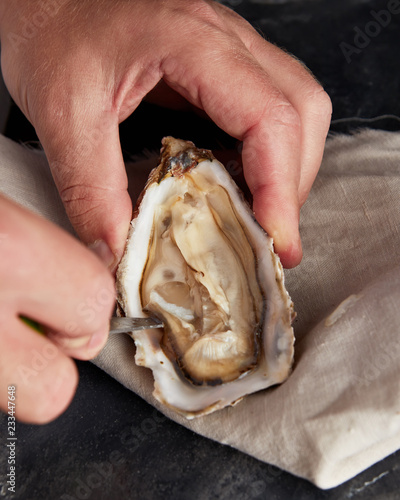 Man opening fresh oyster
