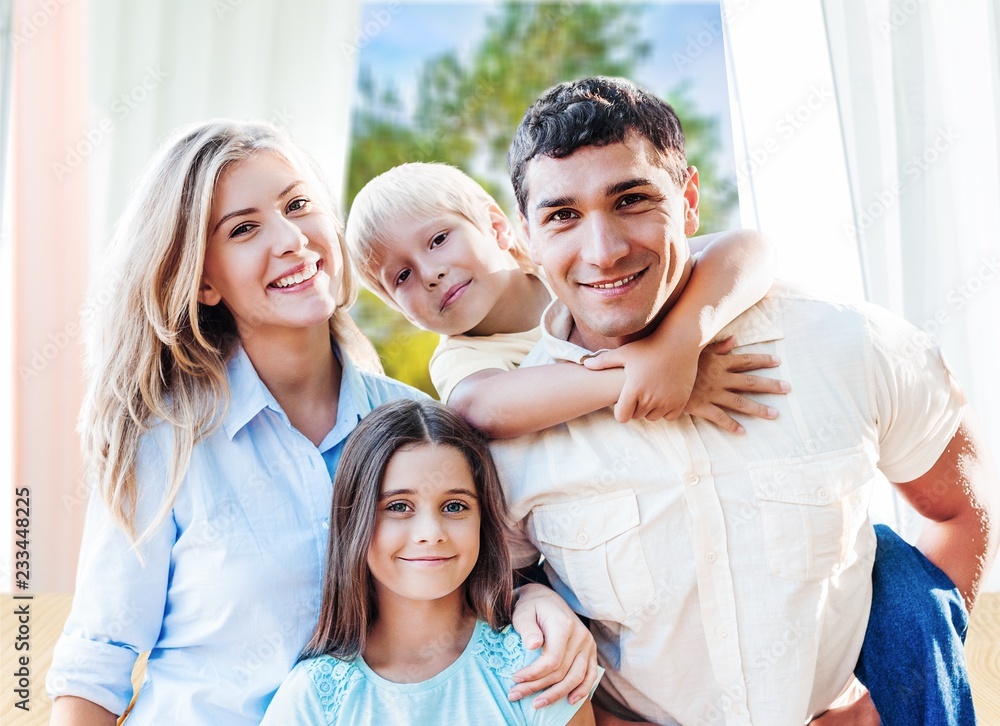 Beautiful smiling family sitting at sofa on background Beautiful smiling family sitting at sofa on background