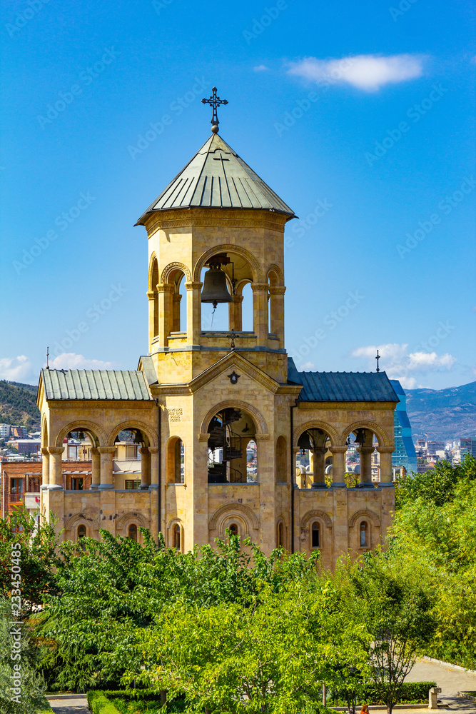 Beautiful view to chapel on site to Sameba Cathedral Tsminda in Tbilisi Holy Trinity . Biggest church Orthodox in Caucasus Georgia region in a sanny day. The main cathedral of the Georgian Orthodoxy