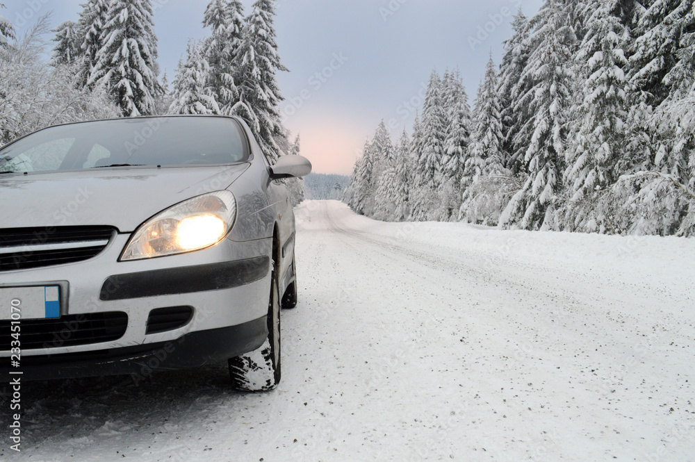 A car on a dangerous and slippery snowy mountain road A car on a dangerous and slippery snowy mountain road