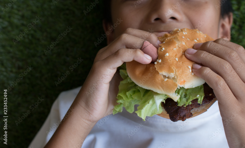 The boy's Hand holding a hamburger