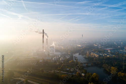 Widok z lotu ptaka na smog nad miastem o poranku, dymiące kominy elektrociepłowni oraz zabudowa miasta - Wrocław, Polska