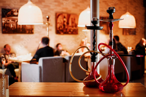 group of red hookahs shisha on table in interior photo