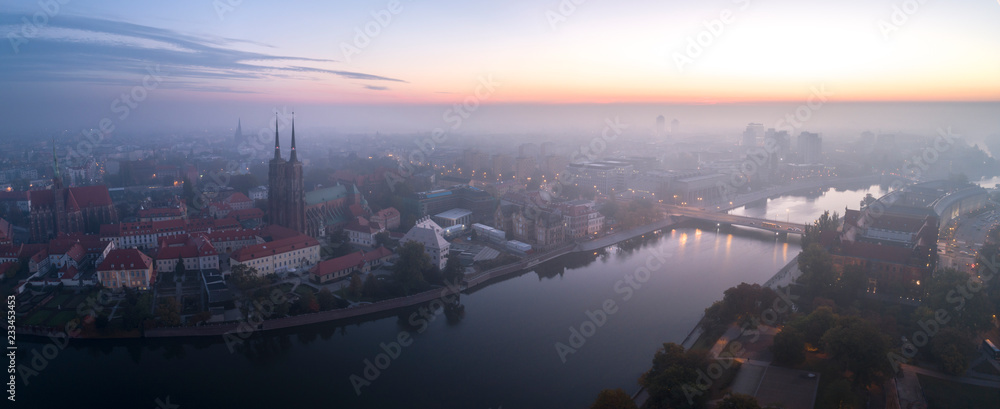 Widok z lotu ptaka na smog nad budzącym się miastem o świcie, w dali budynki okryte mgłą i smogiem - Wrocław, Polska - obrazy, fototapety, plakaty 