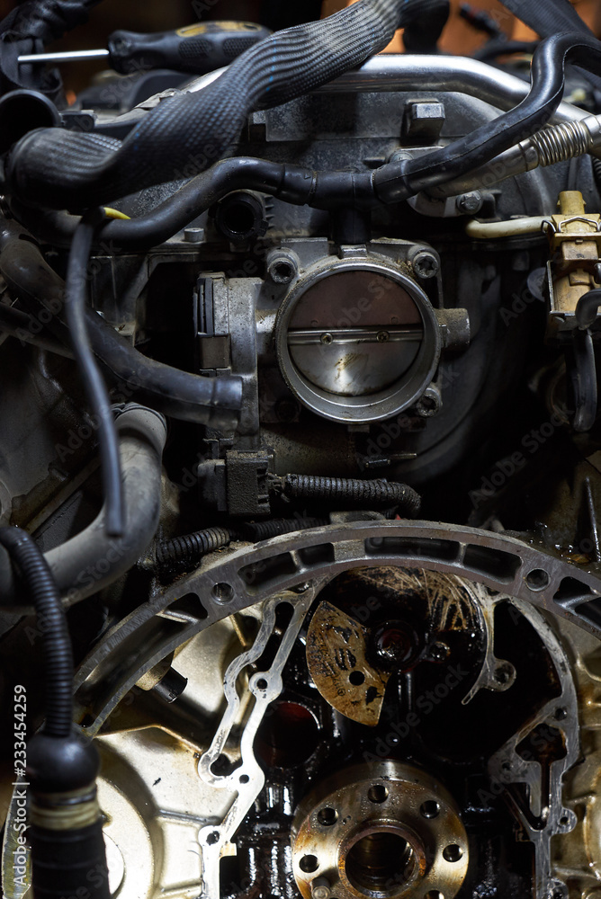 Obraz premium Car engine on crane hook in garage repair service, indoor