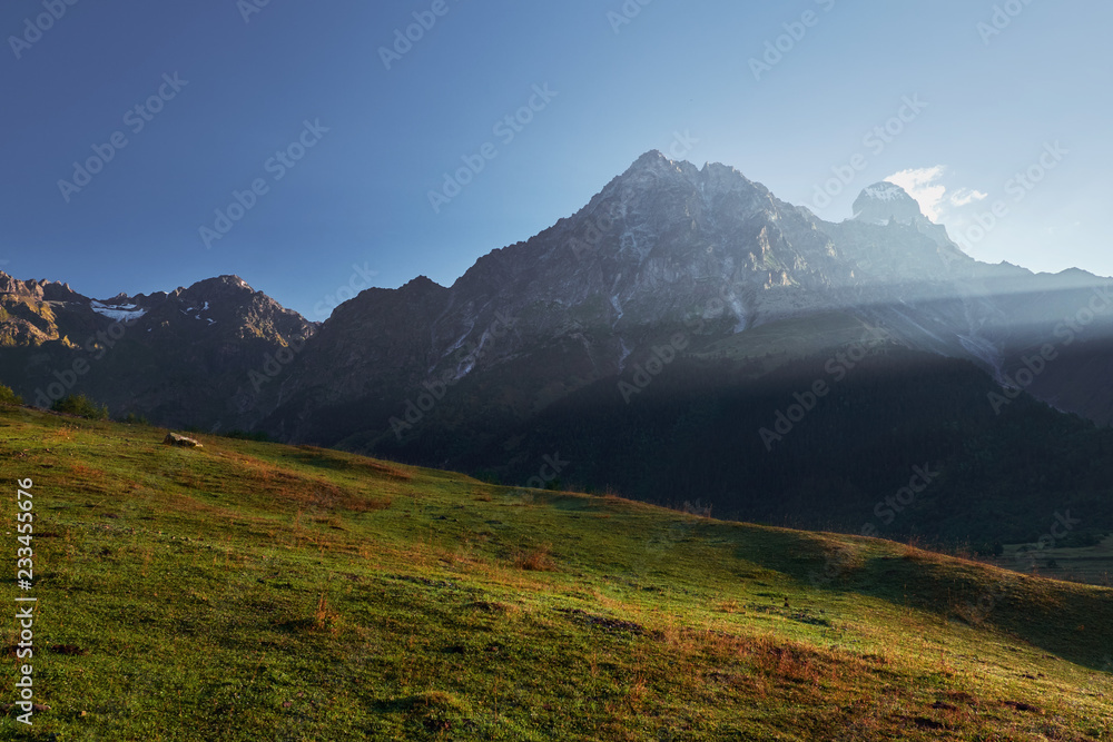 Landscape with view on the top of the Ushba mountain in morning sun rays