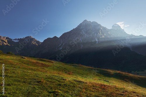 Landscape with view on the top of the Ushba mountain in morning sun rays