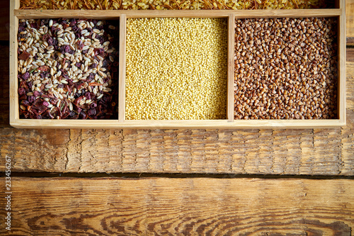 Photos different, colorful types of groats in a wooden square box