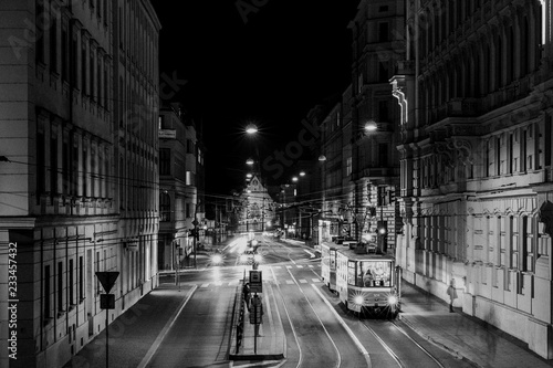 Tram stop Šilingrovo náměstí in Brno passing through public transport through night long street captured in black and white combination