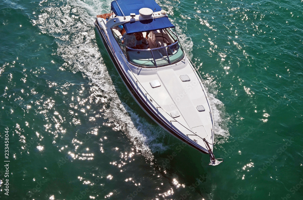 Overhead view of a white motorboat with blue canvas canopy