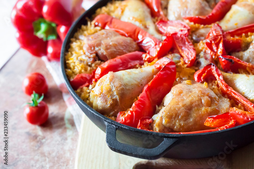 Chicken thighs and legs baked over a bed of rice and red bell pepper