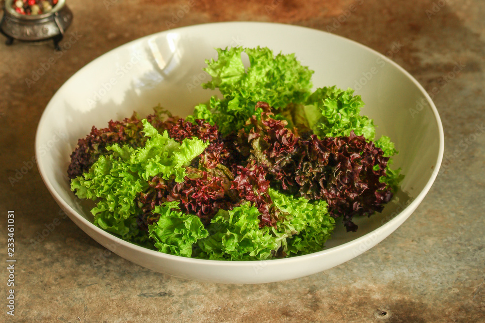 fresh lettuce leaves salad in a white plate on a wooden table background. top view. copy space fresh lettuce leaves salad in a white plate on a wooden table background. top view. copy space