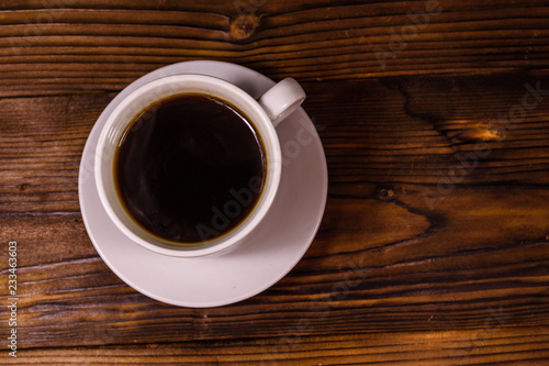 Cup of dark coffee on wooden table. Top view