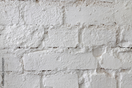 White brick wall. An old brick wall painted with paint and supplemented with plaster. Light background.