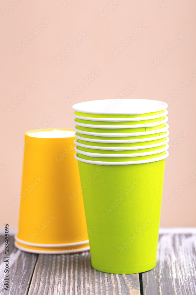 Fototapeta premium Recycling bright and colorful paper cups on wooden table