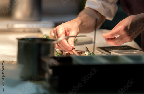 Restaurant chef preparing a plate under a warm light