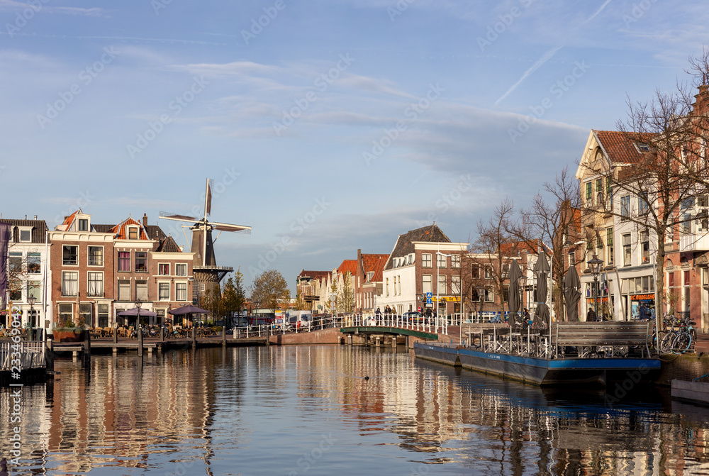 Fototapeta premium Picturesque medieval city of Leiden in the Netherlands with old historic cityscape on a sunny afternoon with a Windmill in the background