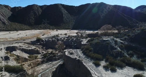 Flying over ravinre of El Leoncito river volume light. Genearl view of valley, mountains, treking wood paths and viewpoints of National Park El Leoncito, San Juan, Argentina  photo