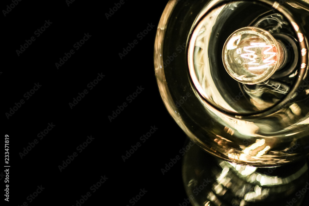 Glass ceiling and Edison light bulb on dark background with space for text. Close-up Glass ceiling and Edison light bulb on dark background with space for text. Close-up