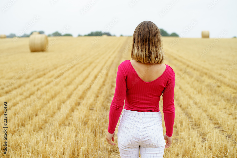 girl walking in a harvested field
