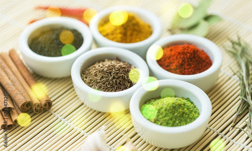 Various colorful spices in bowls on wooden table Various colorful spices in bowls on wooden table