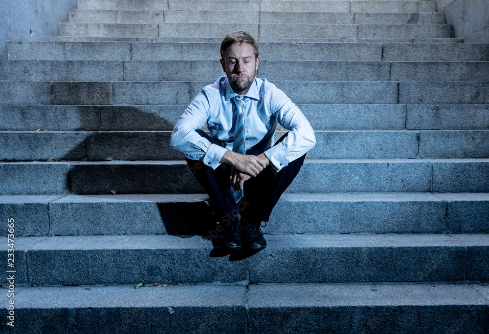 Depressed sad business man in total despair felling hopeless and frustrated sitting in city stairs Depressed sad business man in total despair felling hopeless and frustrated sitting in city stairs