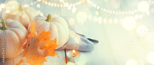 Thanksgiving background. Holiday scene. Wooden table, decorated with pumpkins, autumn leaves and candles