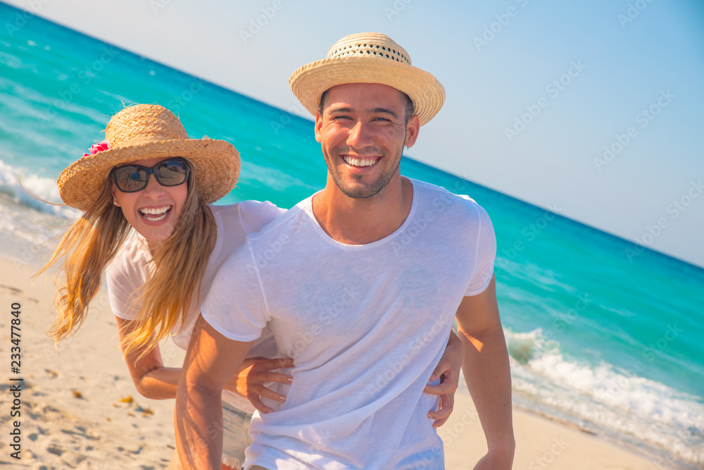 Pareja de jovenes en la playa vestidos de blanco un hermoso día de verano.  foto de Stock | Adobe Stock