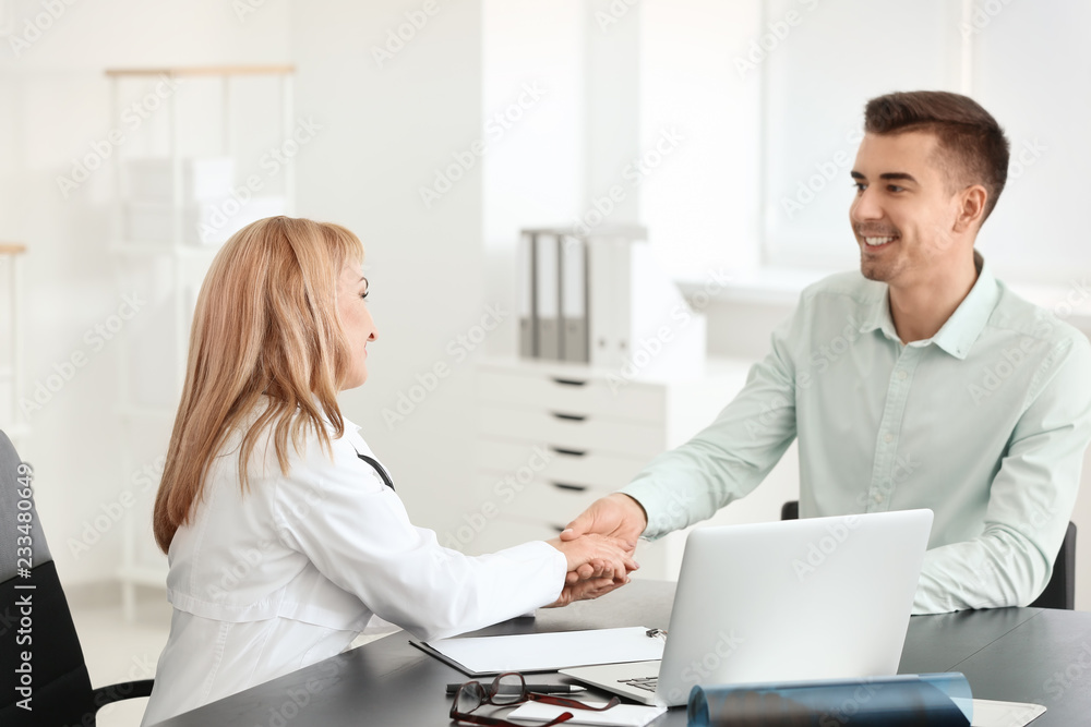 Female doctor consulting young patient in clinic Female doctor consulting young patient in clinic