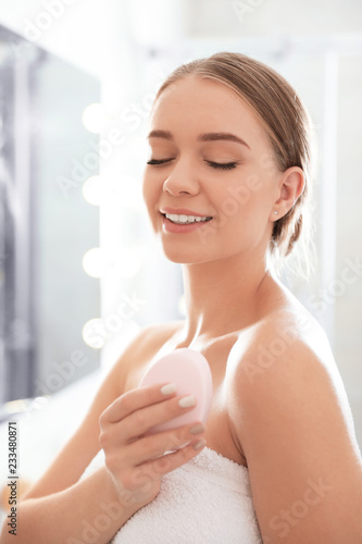 Young woman with soap bar on blurred background