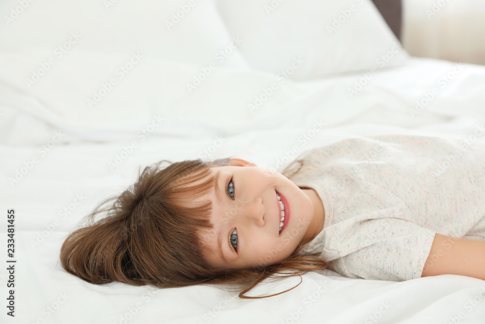 Portrait of cute little girl lying on bed at home Portrait of cute little girl lying on bed at home