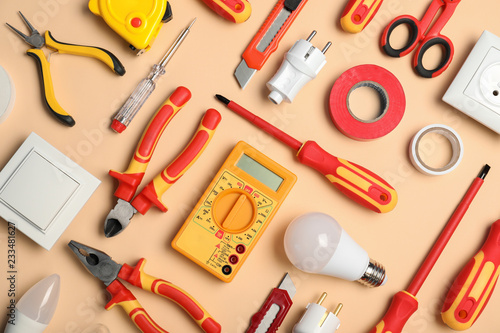 Flat lay composition with electrician's tools on color background