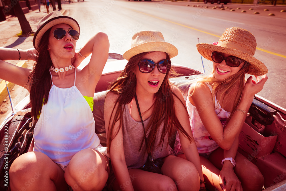 Tres mujeres muy sexys en un coche descapotable disfrutando un día de verano.