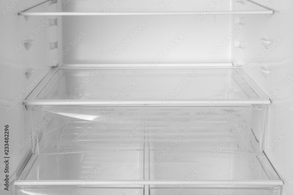 Modern open refrigerator with empty shelves, closeup Modern open refrigerator with empty shelves, closeup