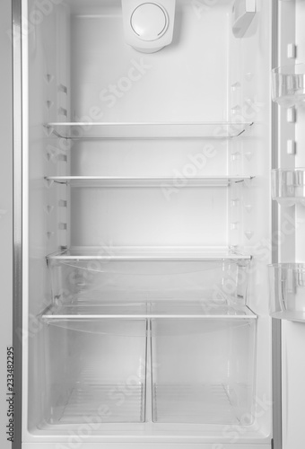 Modern open refrigerator with empty shelves  closeup