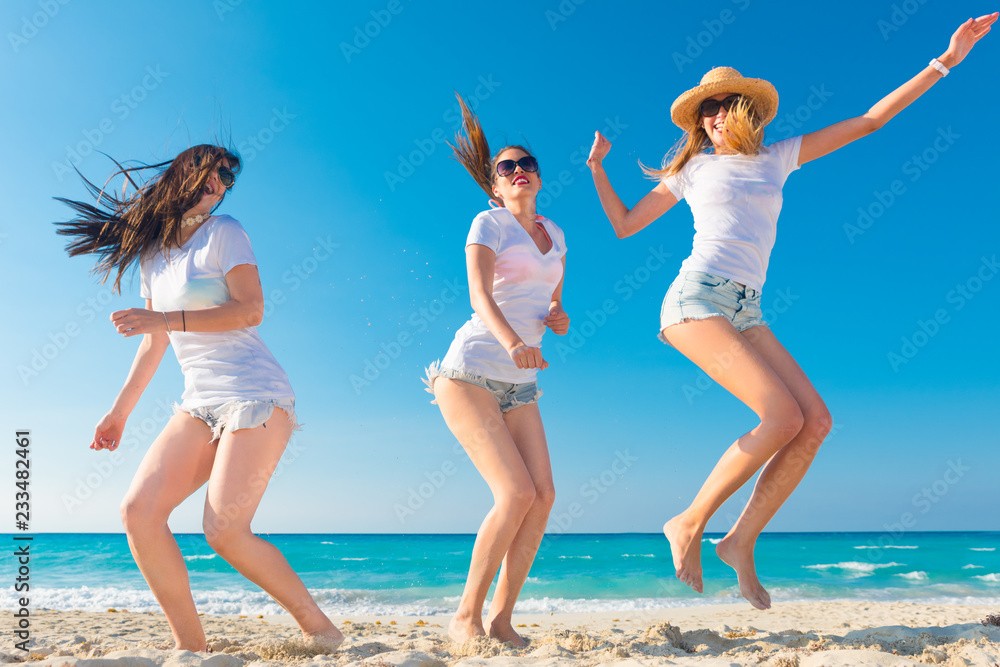 Cuatro amigos con camisetas blancas para anunciar una empresa en la playa.