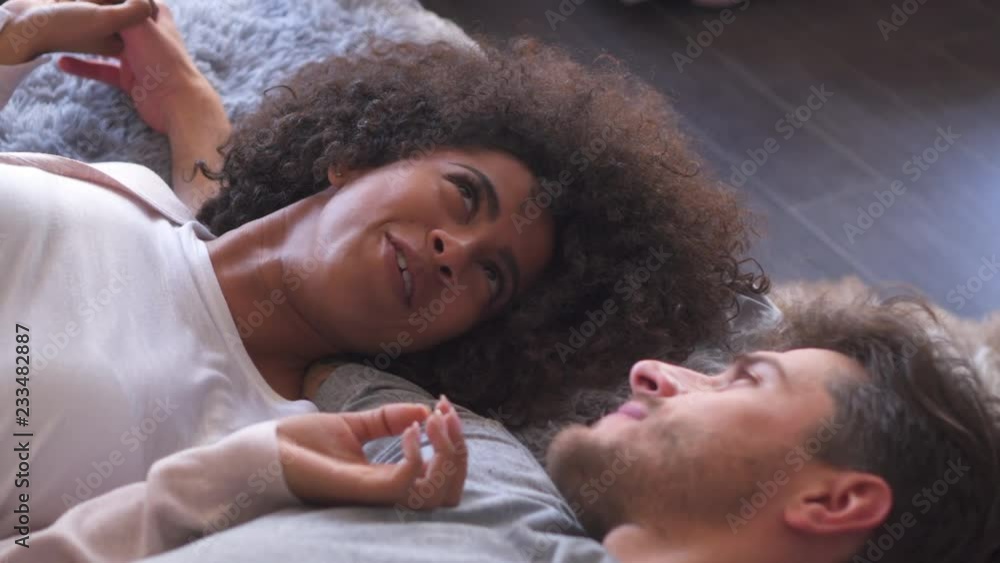 Mixed race couple talking in bed Mixed race couple talking in bed